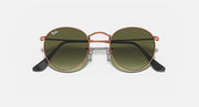Round metal sunglasses with rose-gold frame and olive tinted lenses, black arms