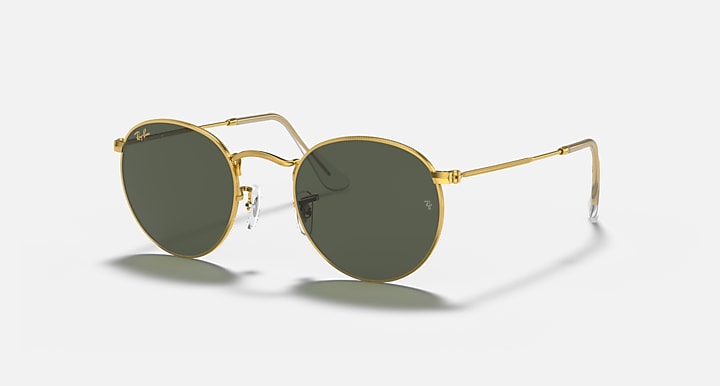 Round metal sunglasses with gold frame and dark green mirrored lenses, angled side view.