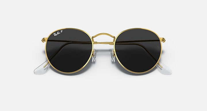 Gold round metal sunglasses with black lenses and clear temple tips, front close-up.