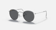 Round metal sunglasses with dark gray lenses and shiny silver frame, side view.