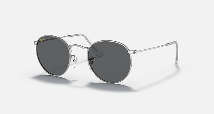 Round metal sunglasses with dark gray lenses and shiny silver frame, side view.