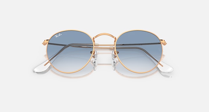 Round metal sunglasses by Ray-Ban, rose gold frames, blue mirrored lenses, angled front