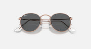 Round metal sunglasses with rose gold frames and dark lenses, angled front view.