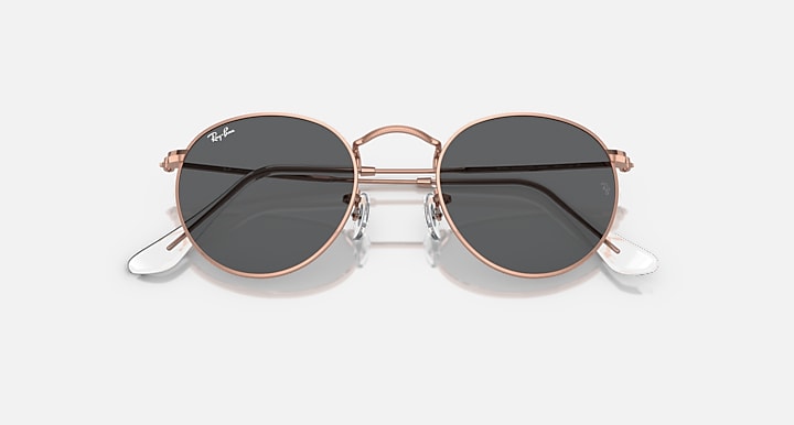 Round metal sunglasses with rose gold frames and dark lenses, angled front view.