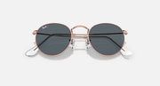 Round metal sunglasses with rose gold-tone frame and dark lenses with glare