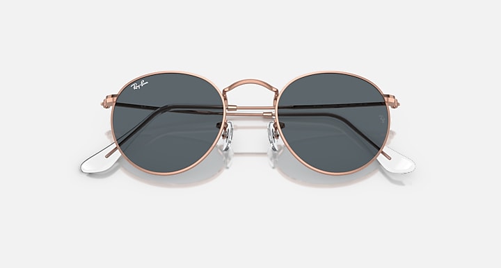 Round metal sunglasses with rose gold-tone frame and dark lenses with glare