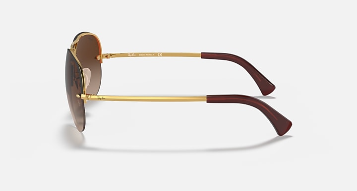 Ray-Ban aviator sunglasses with gold frame and dark brown temple tips, side view