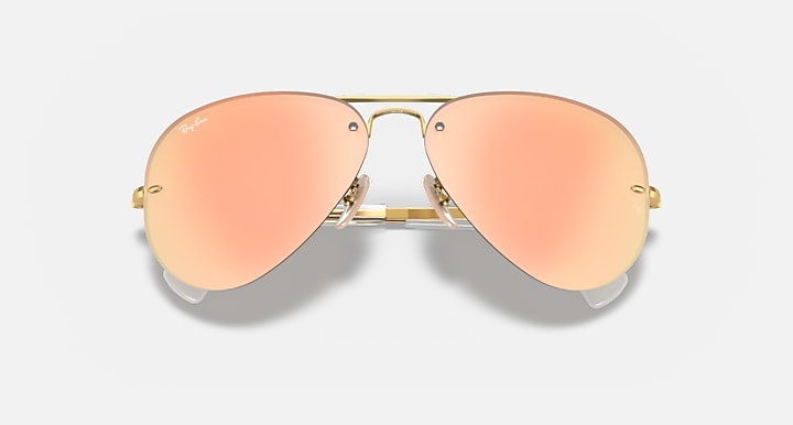 Aviator sunglasses with gold frame and peach gradient lenses, close front view