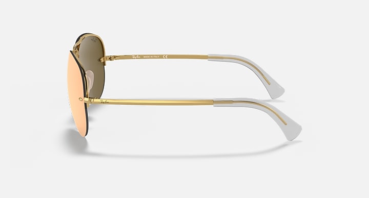 Aviator sunglasses with peach tint lenses and gold frame, temple side profile