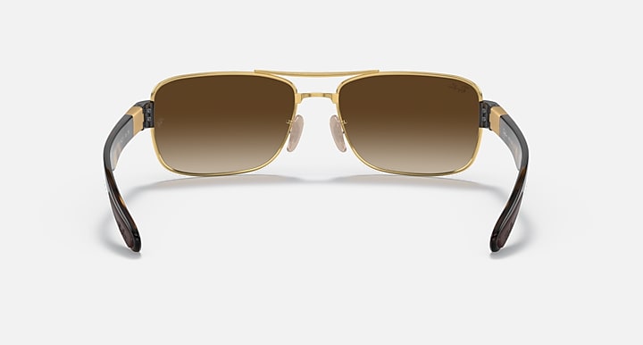 Brown-tinted sunglasses with gold frame and dark temple tips, front view.
