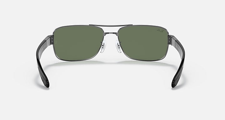 Dark green-lens sunglasses with thin metal frame and angled black temple tips.