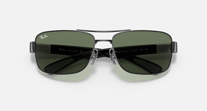 Green tinted sunglasses with dark metal frame, straight-on view of both lenses.