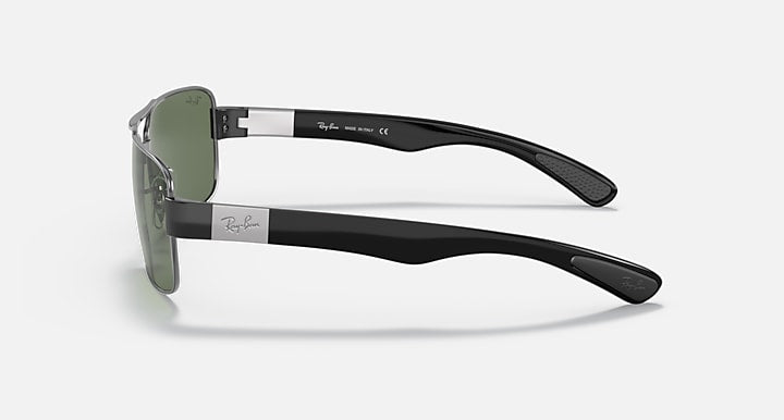 Side view of dark metal sunglasses with green lenses and black textured temples.