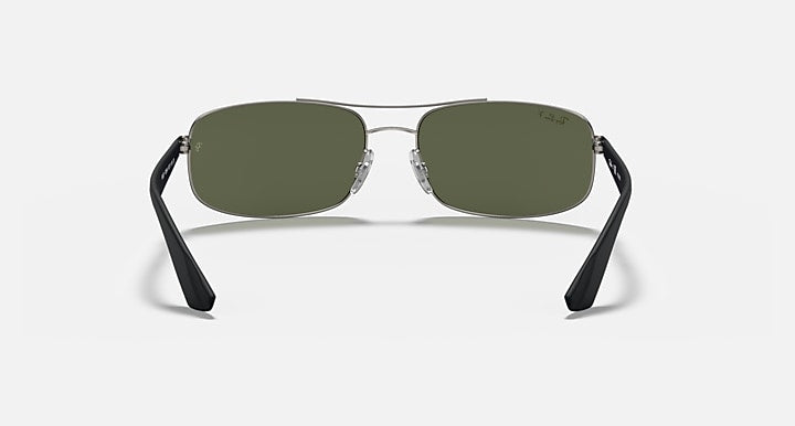 Sunglasses with dark green lenses and clear metal bridge with black end tips