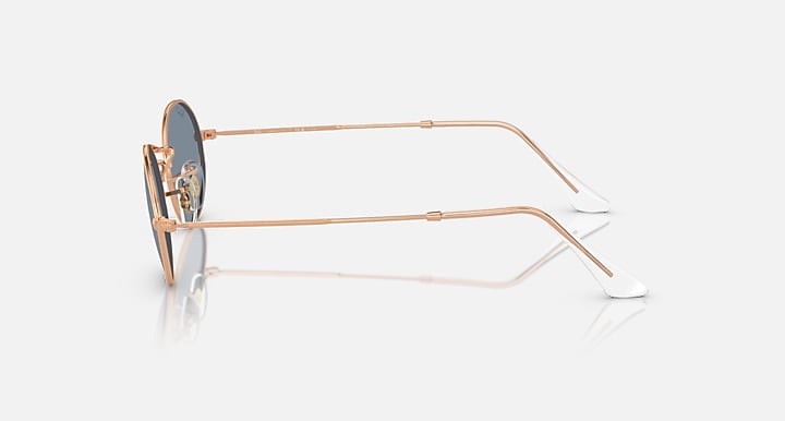 Ray-Ban round sunglasses with blue-gray lenses and rose gold metal frame, temple side view
