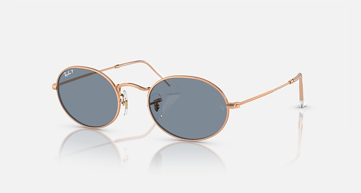 Ray-Ban round sunglasses with blue-gray lenses and rose gold metal frame, side view