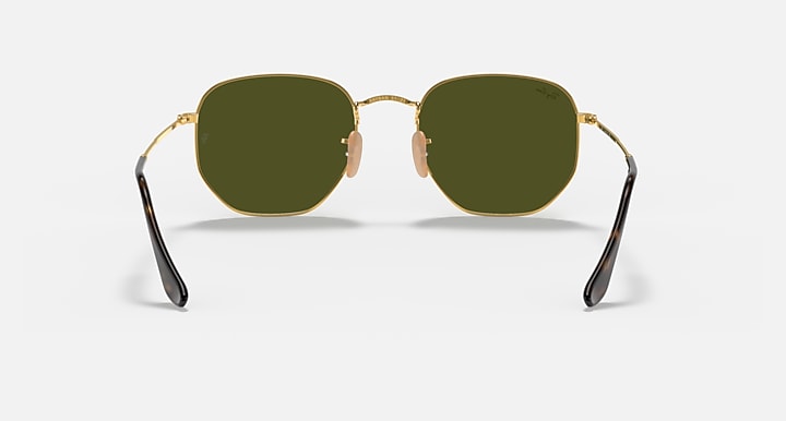 Hexagonal flat sunglasses with gold frame and dark olive tinted lenses, dark temples