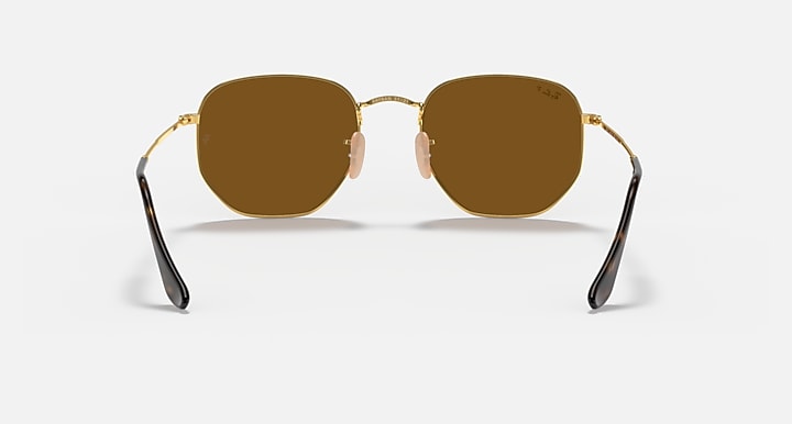 Ray-Ban hexagonal flat sunglasses with dark brown lenses and gold frame, front view