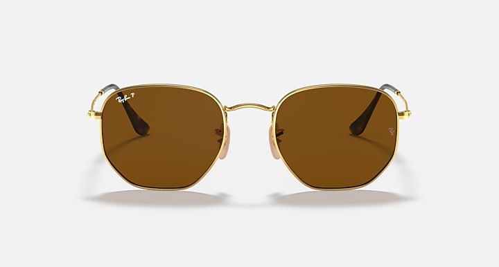 Ray-Ban hexagonal flat sunglasses with dark brown lenses and gold frame, front view