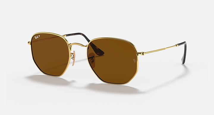 Ray-Ban hexagonal flat sunglasses with dark amber lenses and gold frame, side angle