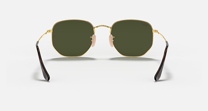 Hexagonal flat sunglasses with gold frame and dark green lenses, center bridge