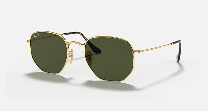 Hexagonal flat sunglasses with gold frame and dark green lenses, black temple tips