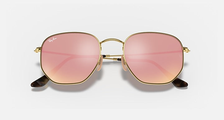 Ray-Ban hexagonal flat sunglasses with rose-pink lenses and gold frame, close front