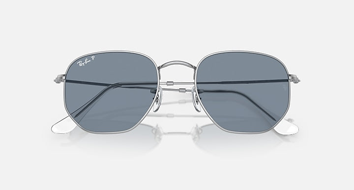 Silver hexagonal flat sunglasses with dark grey lenses and rose-shaped metal nose bridge