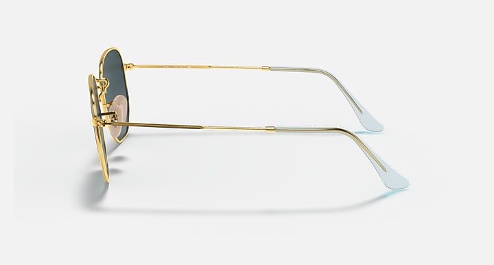 Ray-Ban hexagonal flat sunglasses, side view, gold metal frame with blue-tint lenses