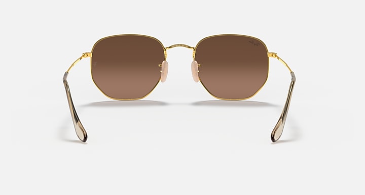 Hexagonal flat sunglasses with gold frame and brown lenses, center hinge detail