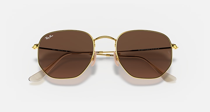 Hexagonal flat sunglasses with gold frame and brown mirror lenses, top angle