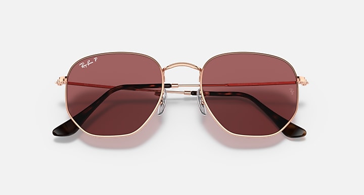 Rose gold hexagonal flat sunglasses with dark rose-tinted lenses and slim metal arms