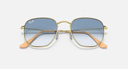 Hexagonal sunglasses front view, gold frame with blue gradient lenses and orange temples.