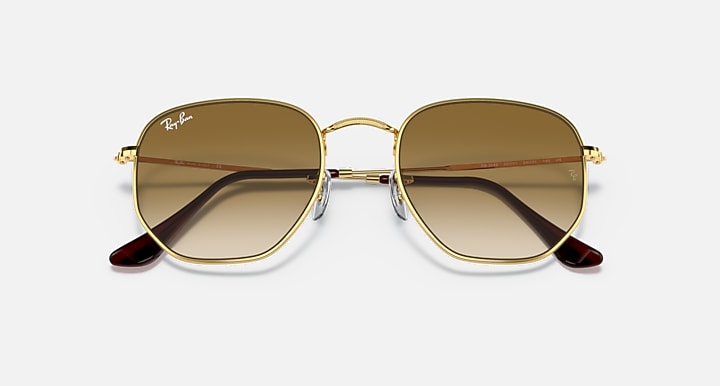 Hexagonal sunglasses with gold frame, brown gradient lenses, and burgundy temple tips.