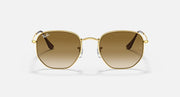 Hexagonal sunglasses, gold frame with brown gradient lenses and dark metal temples.