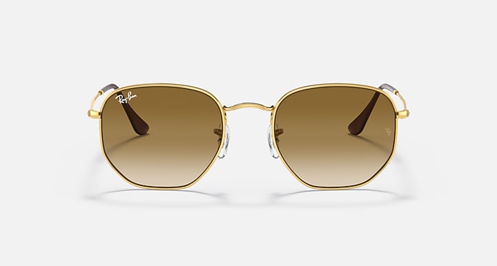 Hexagonal sunglasses, gold frame with brown gradient lenses and dark metal temples.