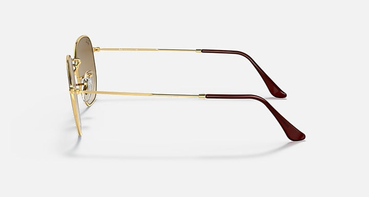 Hexagonal sunglasses side view, gold frame with brown lenses and burgundy temples.