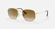 Hexagonal sunglasses with gold frame, brown lenses, and dark temple accents.
