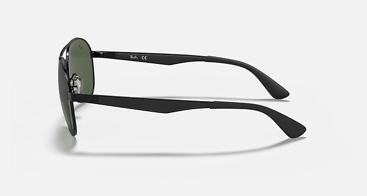 Aviator sunglasses with matte black frame and dark green lenses, side view