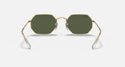 Octagonal sunglasses with gold frame and dark green lenses, angled front