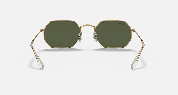 Octagonal sunglasses with gold frame and dark green lenses, angled front