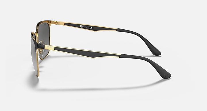 Metal sunglasses side view with dark lenses, black arms and gold-tone frame