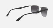 Sunglasses with dark gray lenses and silver frame in angled side view; temple visible