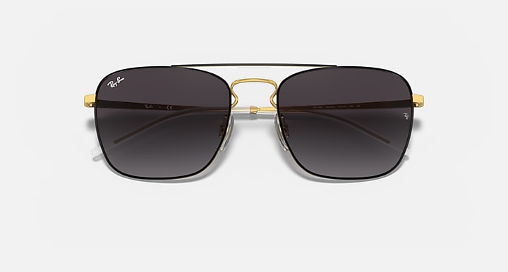 Square sunglasses with dark lenses, gold bridge, and black outer frames