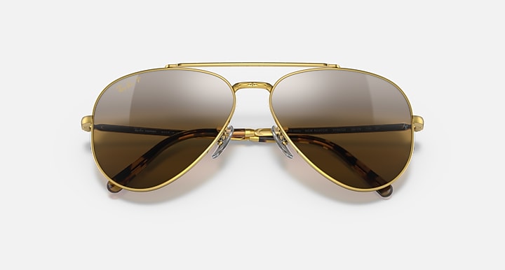 Aviator sunglasses with gold frame and dark mirrored lenses; slim metal bridge