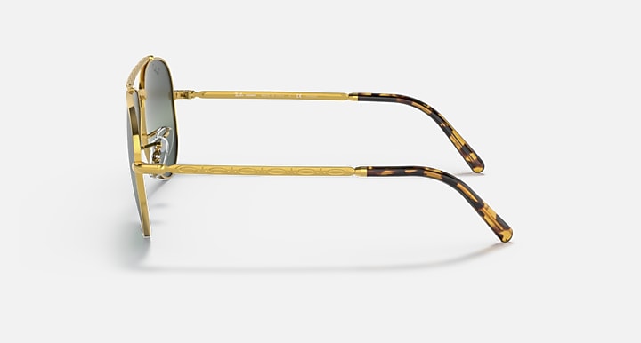 Aviator sunglasses with gold frame and tortoiseshell-pattern temples; green lens tint