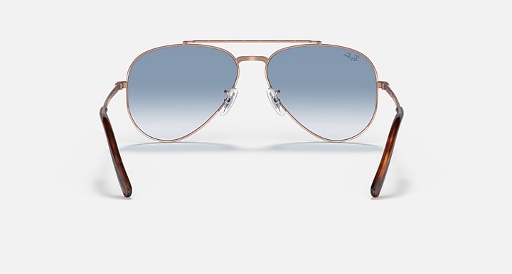Rose gold aviator sunglasses with blue gradient lenses and curved top rim