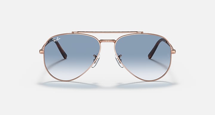 Rose gold aviator sunglasses with clear-to-blue gradient lenses and nose bridge