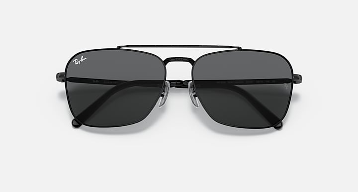 Black sunglasses with dark smoke lenses and a sculpted bridge between lenses