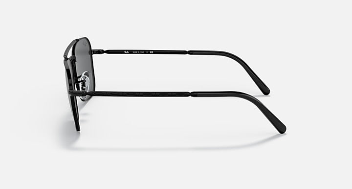 Black sunglasses shown from the side with curved metal arms and dark lens